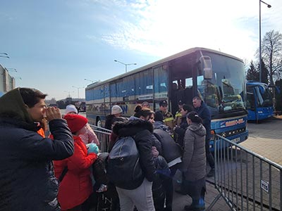 people waiting in line to board bus